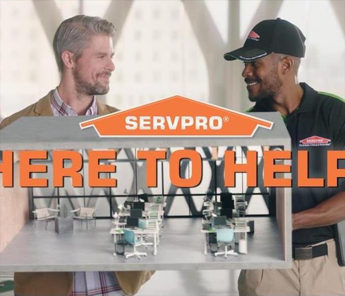 SERVPRO orange house logo with here to help with a SERVPRO employee and a customer in the background.