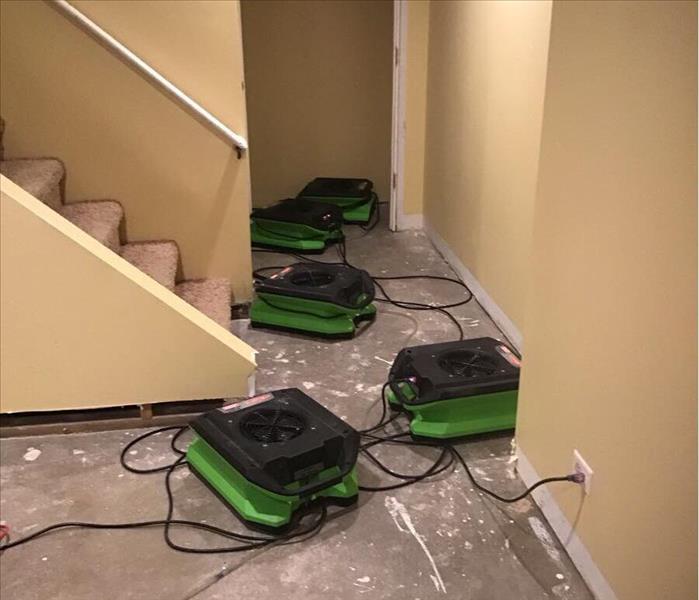 Dry concrete floor of a basement with SERVPRO air movers.