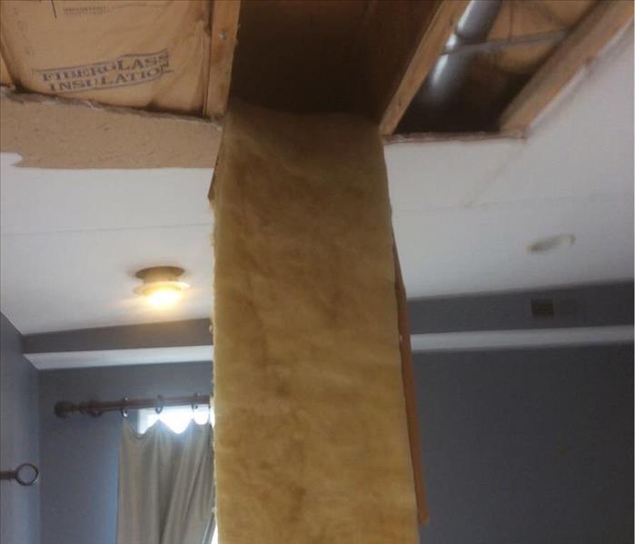 Insulation hanging down from a ceiling.